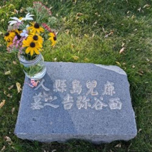 garvestone withe Japanese character engraved into the granite and a jar of sunflowers on the corner
