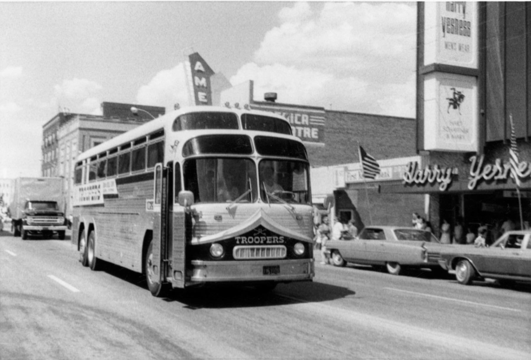 The Troopers pioneered long-distance travel for drum corps. Here, a Troopers bus arrives in Casper driving down Center Street past the America Theatre and Harry Yesness men’s store, 1970. Troopers Archives #1910.