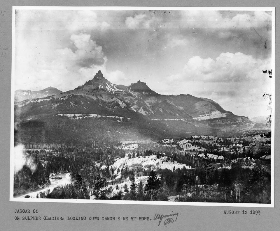 black and white photo of two very sharp pointed peaks near each other above a wide valley.