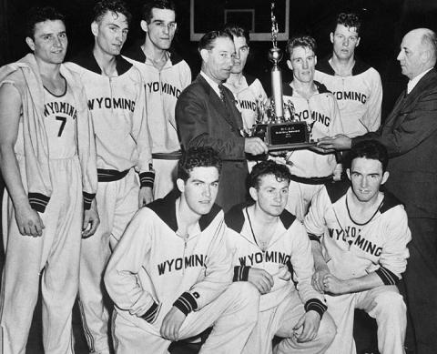 The 1943 UW men's basketball team, shortly after its 46-34 victory over Georgetown for the NCAA championship. Kenny Sailors is just to the right of the trophy.