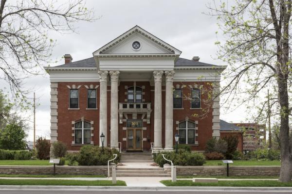 two-story brick building with four columns framing the front entrance