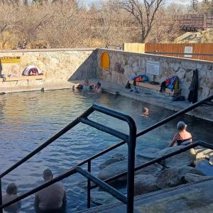 View down stairsteps into are walled-in pool with swimmers on a cold day