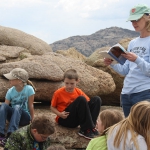 Teacher Debbie LaChance reads from Oregon Trail diaries to fourth graders from Oregon Trail Elementary School, Casper, Wyo. on the top of Independence Rock, May 2013. Tom Rea photo.