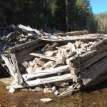 Before entering the flume, ties were held in log dams.  The remains of the Warm Spring holding dams—four rock-filled log cribs—are located about 300 yards south of the bridge over Warm Spring Creek on the Union Pass Road. E. Rosenberg, 2010.