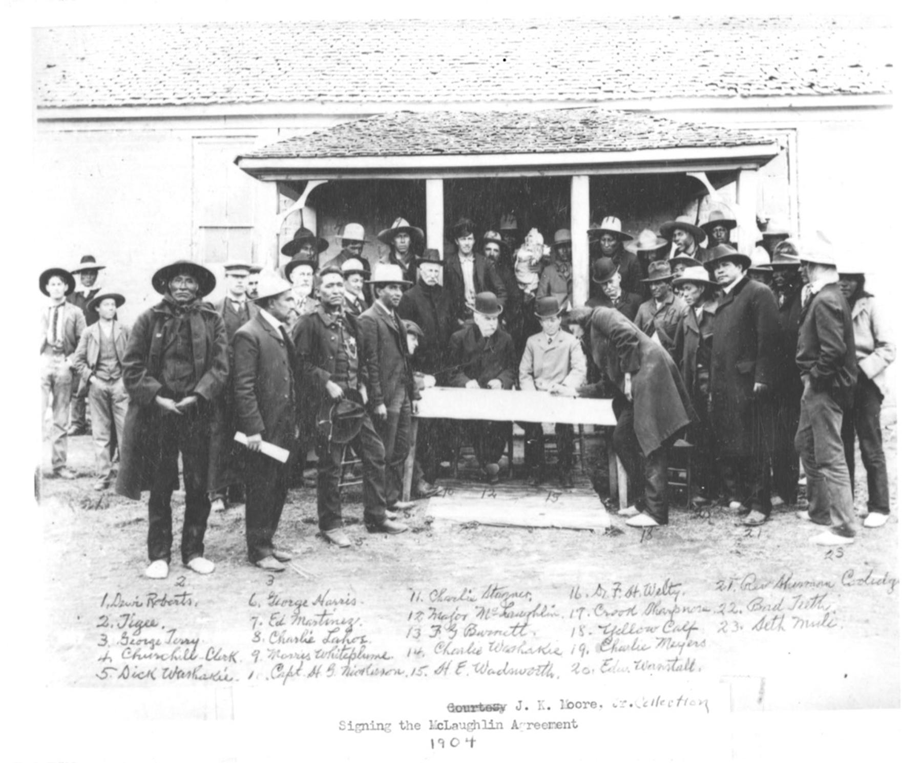 Arapaho Chief Yellow Calf signs the agreement ceding tribal lands north of the Wind River, 1904. Congressman Frank Mondell the following year led the effort to amend the agreement, without consulting the tribes. Government negotiator James McLaughlin is at the table in a derby hat and dark coat. American Heritage Center.