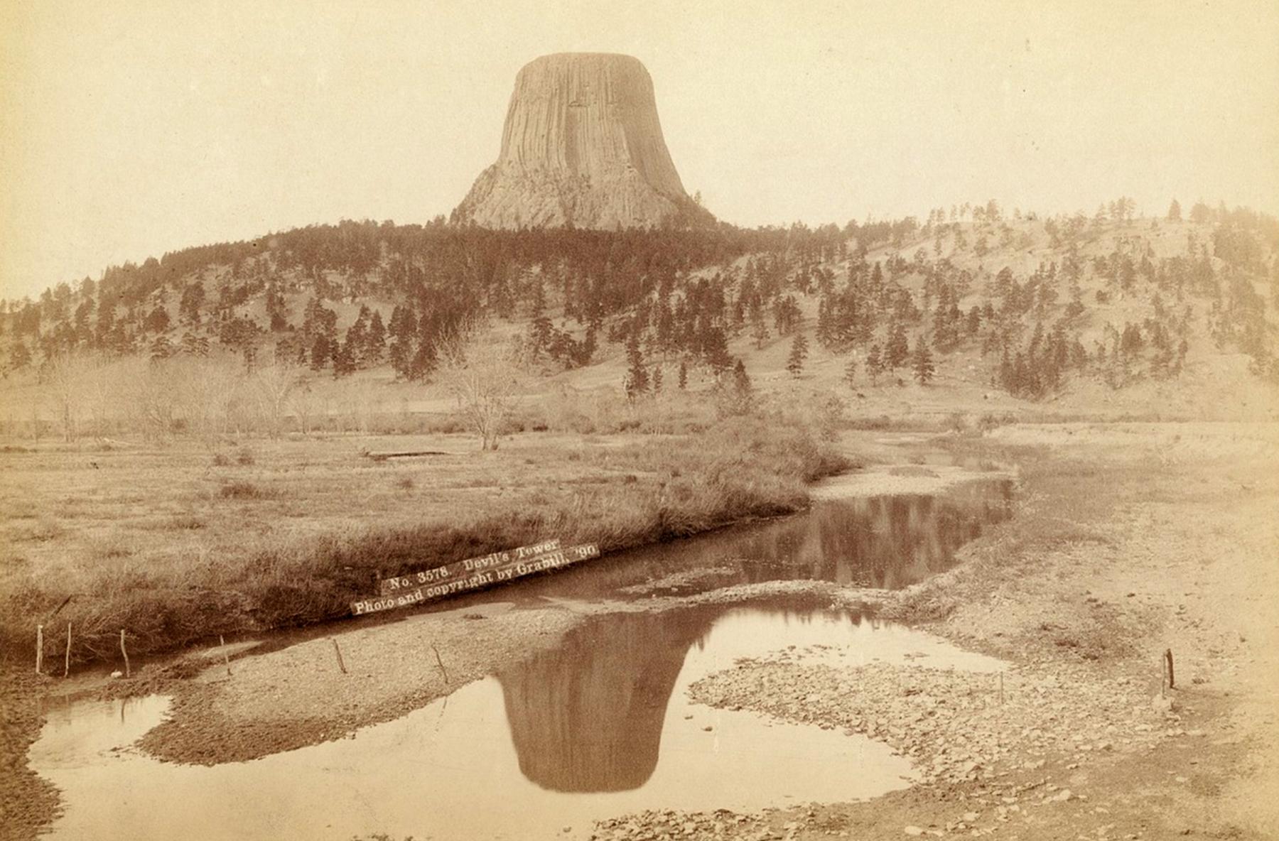 Devils Tower in 1890, 16 years before President Theodore Roosevelt declared it a national monument with brand-new powers granted him by Congress. The low level of the Belle Fourche River may show the picture was taken in the fall of the year. The photo is by Black Hills area photographer John Grabill. 