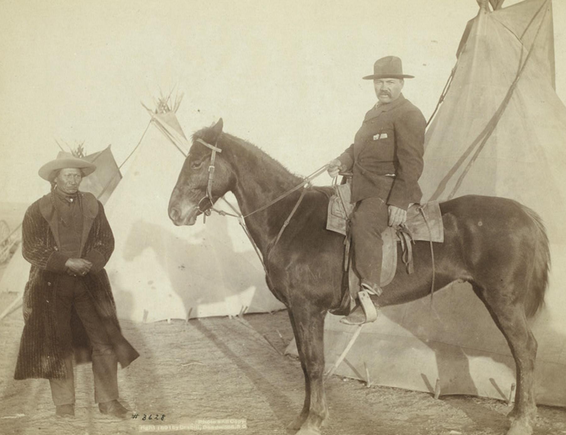 This photo of Grouard at the home of the Oglala Chief Rocky Bear, left, was taken in 1891, probably on the Pine Ridge Reservation, by Black Hills area photographer John Grabill. Grouard’s life from mail carrier, to captive, to adopted brother to Sitting Bull, to scouting for Crook in his campaigns against the Lakota, reveals the complicated relationships and loyalties of the changing West. Library of Congress. 