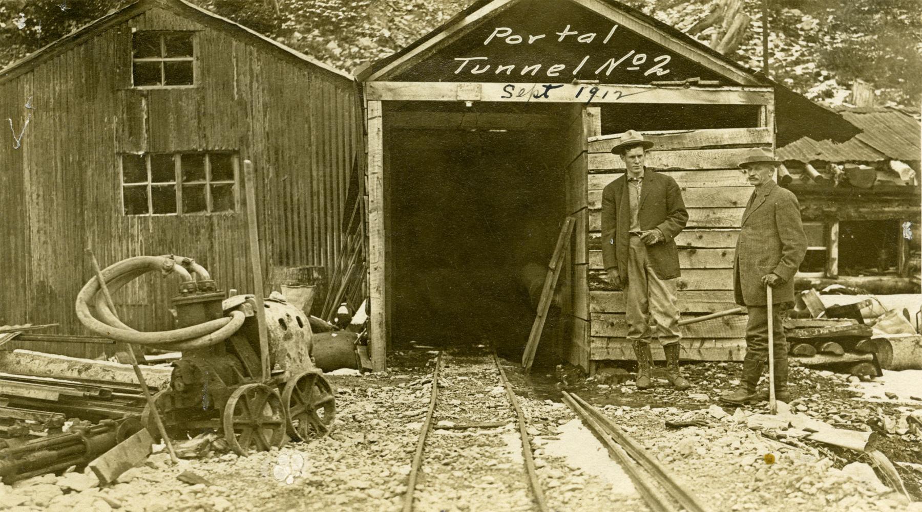 The Winona Gold & Copper Mining Company, a consortium of well-financed Colorado men, bought claims on Sulphur Creek high above Sunlight Basin in 1903. They  excavated a pair of tunnels on the Greenhorn Claim following veins of copper ore.  But they were 60 mountain miles from a railroad, and the operation never paid. Shown here, the mouth of Tunnel No. 2, 1912. Park County Archives.