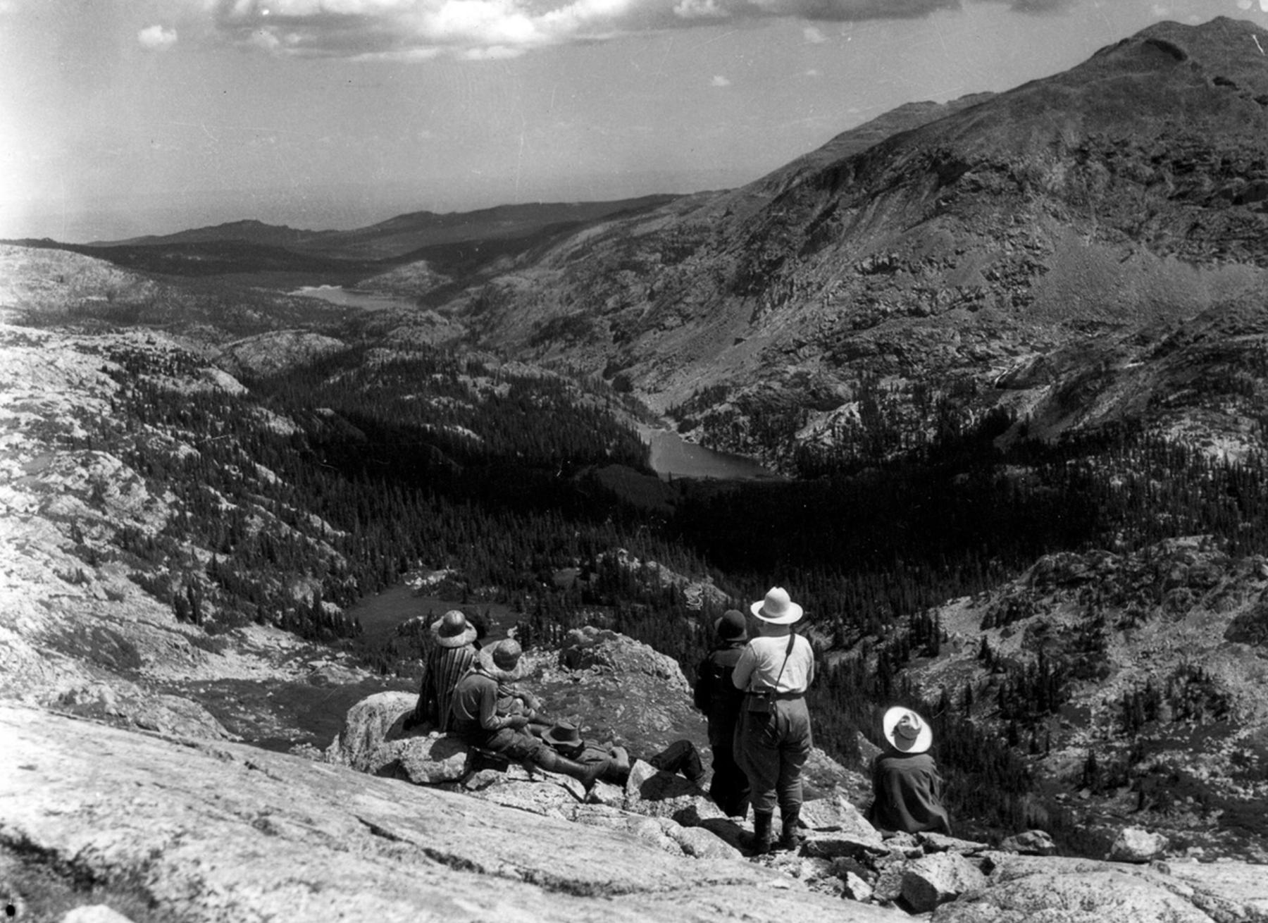 Looking west from the Bighorns near Cloud Peak down the Paint Rock drainage toward the Bighorn Basin. Lake Solitude is at the center of the photo in the middle distance. The photo was taken by Elsa Spear Byron of the Spear-O-Wigwam dude ranch; the people in the foreground are most likely dudes who came over Geneva pass and into the drainage on a pack trip—the same route Howard Zahniser and the Schunks would use in the next decade. The Wyoming Room, Sheridan County Fulmer Public Library.