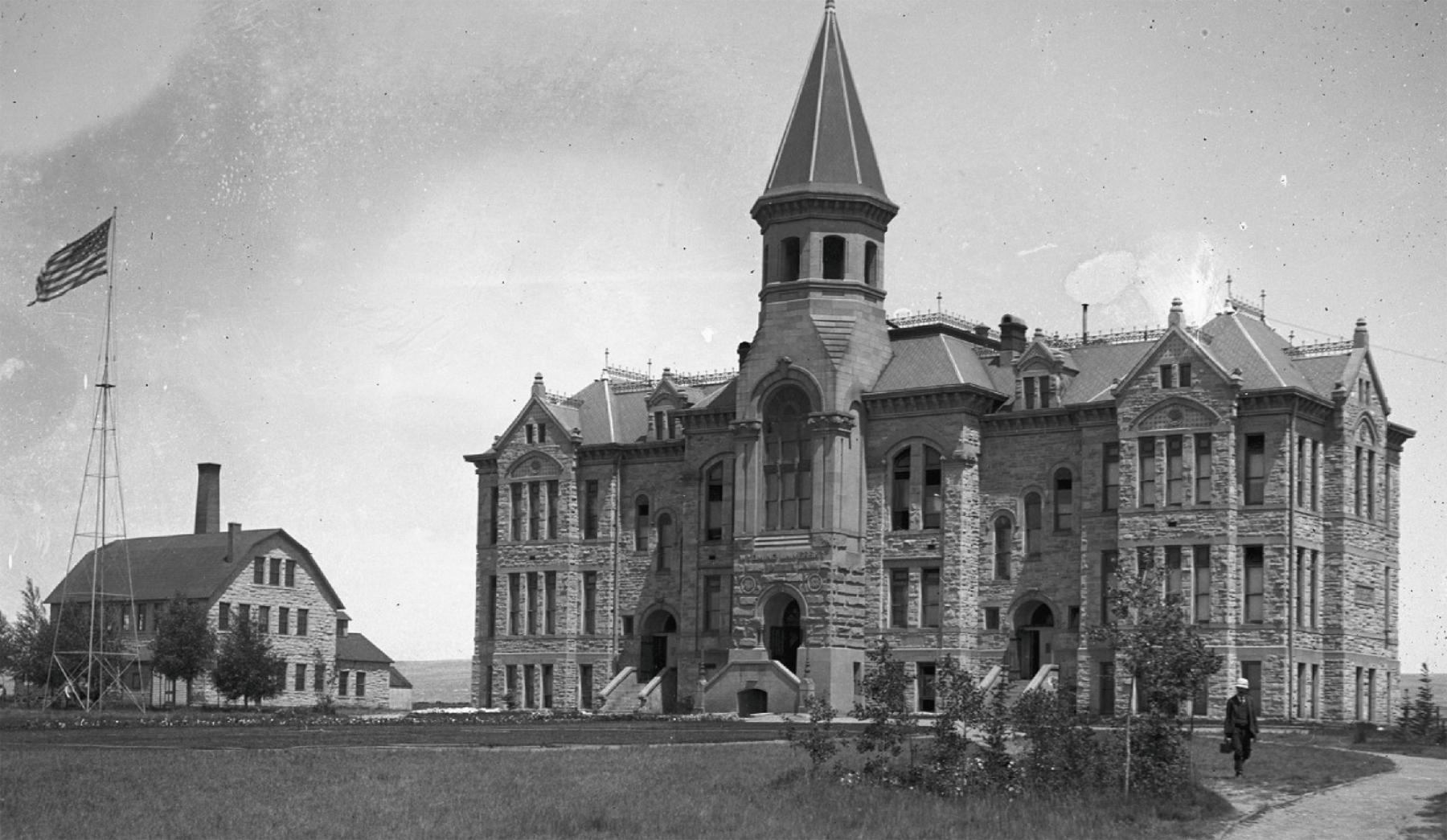 Old Main Old Main building at the University of Wyoming, a stone building of at least three floors, with a large steeple-like tower over the main entrance