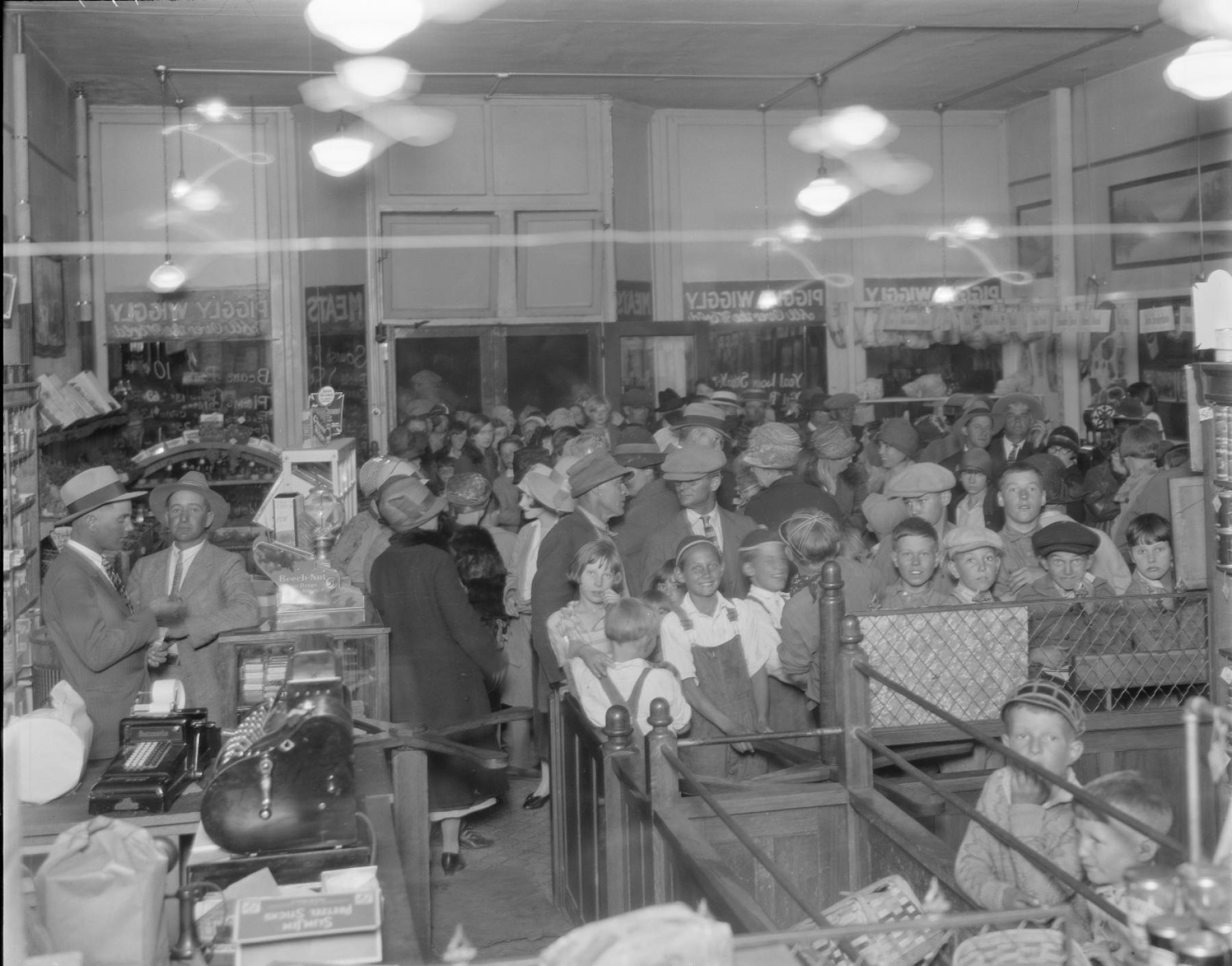 Store interrior shows dozens of people crowded shoulder to shoulder