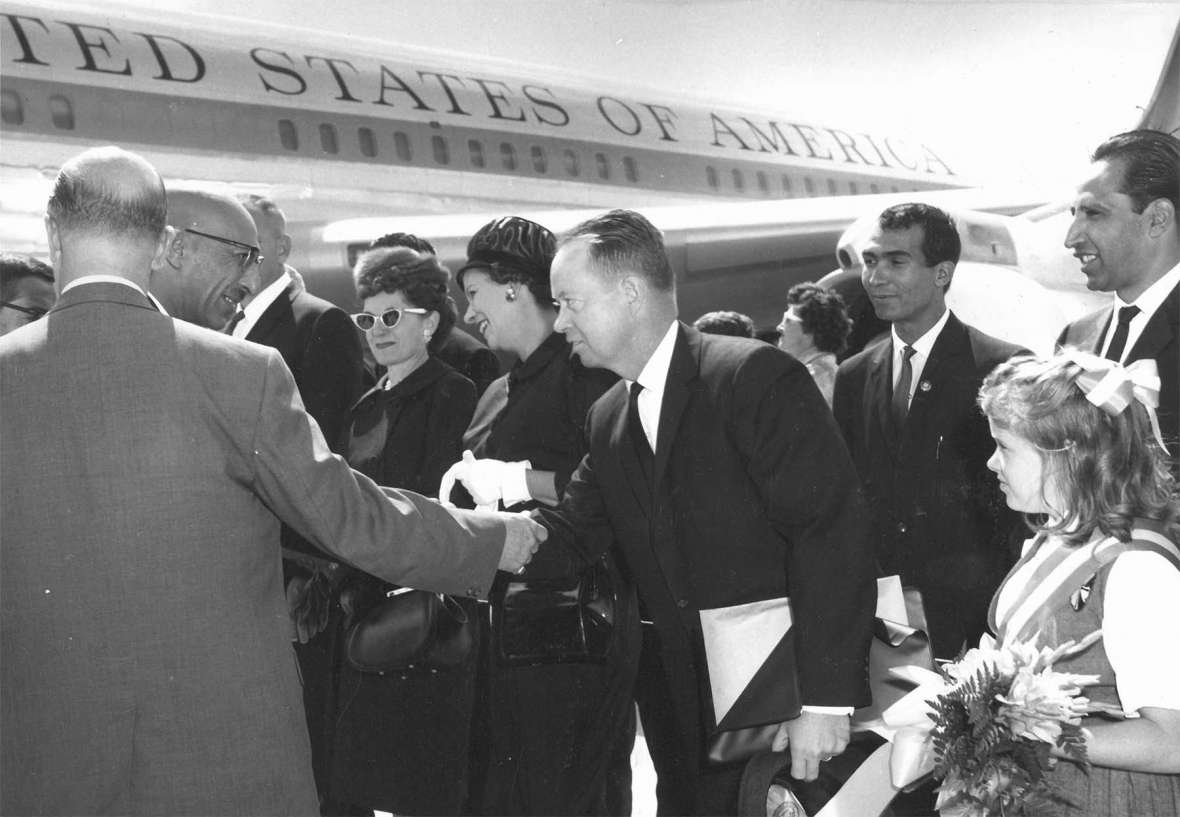 In September 1963 the king and queen of Afghanistan visited the University of Wyoming. At the Cheyenne airport, the king, Zahir Shah, in glasses, shakes hands with G. W. Arnold, director of the Afghanistan program at UW. At the center of the photo are Mrs. N. W. Hilston, wife of the dean of UW’s agriculture college; Mrs. Arnold, and Arnold. American Heritage Center, University of Wyoming.