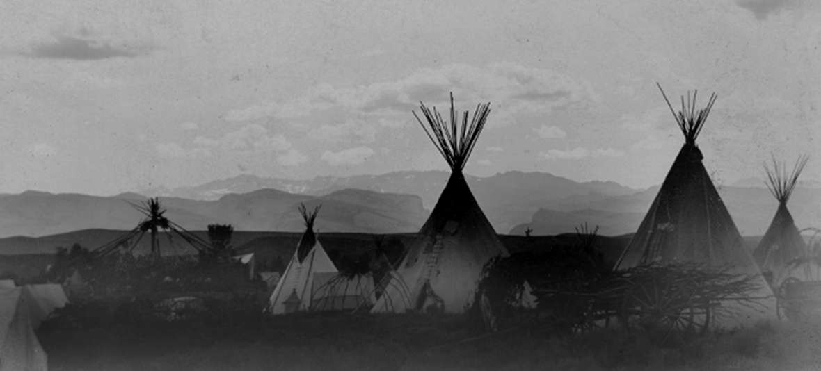 An undated photo of an Arapaho village on Little Wind River on the Shoshone Reservation. The mix of tents, tipis and wagons suggests the photo may be from the late 1800s. Wyoming State Archives.