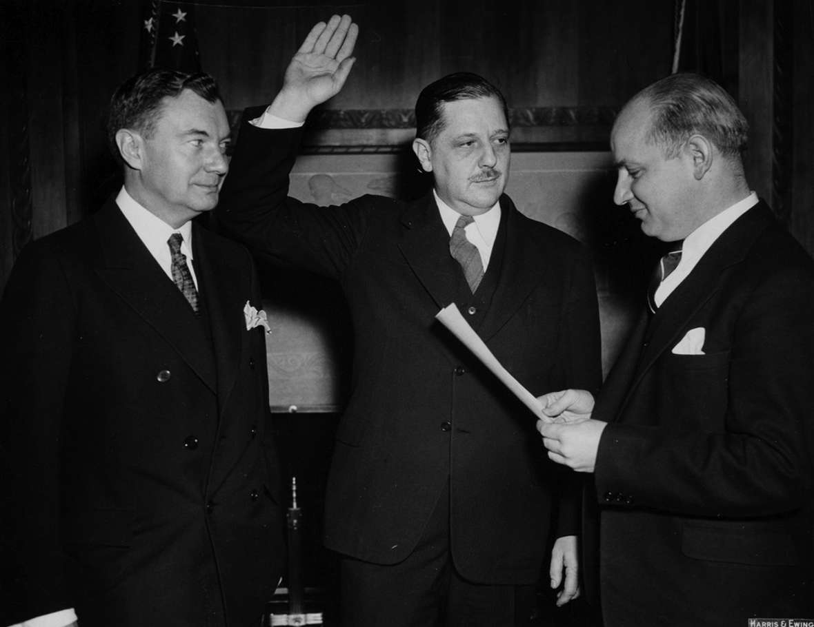 Thurman Arnold is sworn in as assistant U.S. attorney general in charge of the Justice Department’s Antitrust Division, March 22, 1938. On the left is U.S. Solicitor General Robert H. Jackson; on the right is Homer Cummings, attorney general. Arnold is in the middle. American Heritage Center.