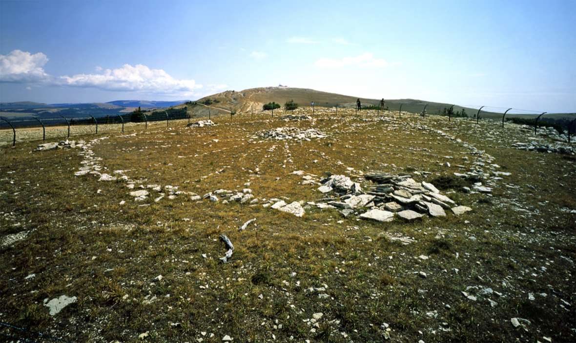 Looking east across the Medicine Wheel toward Medicine Mountain, before the steel-mesh fence was replaced with the current one. Richard Collier, Wyoming SHPO. 