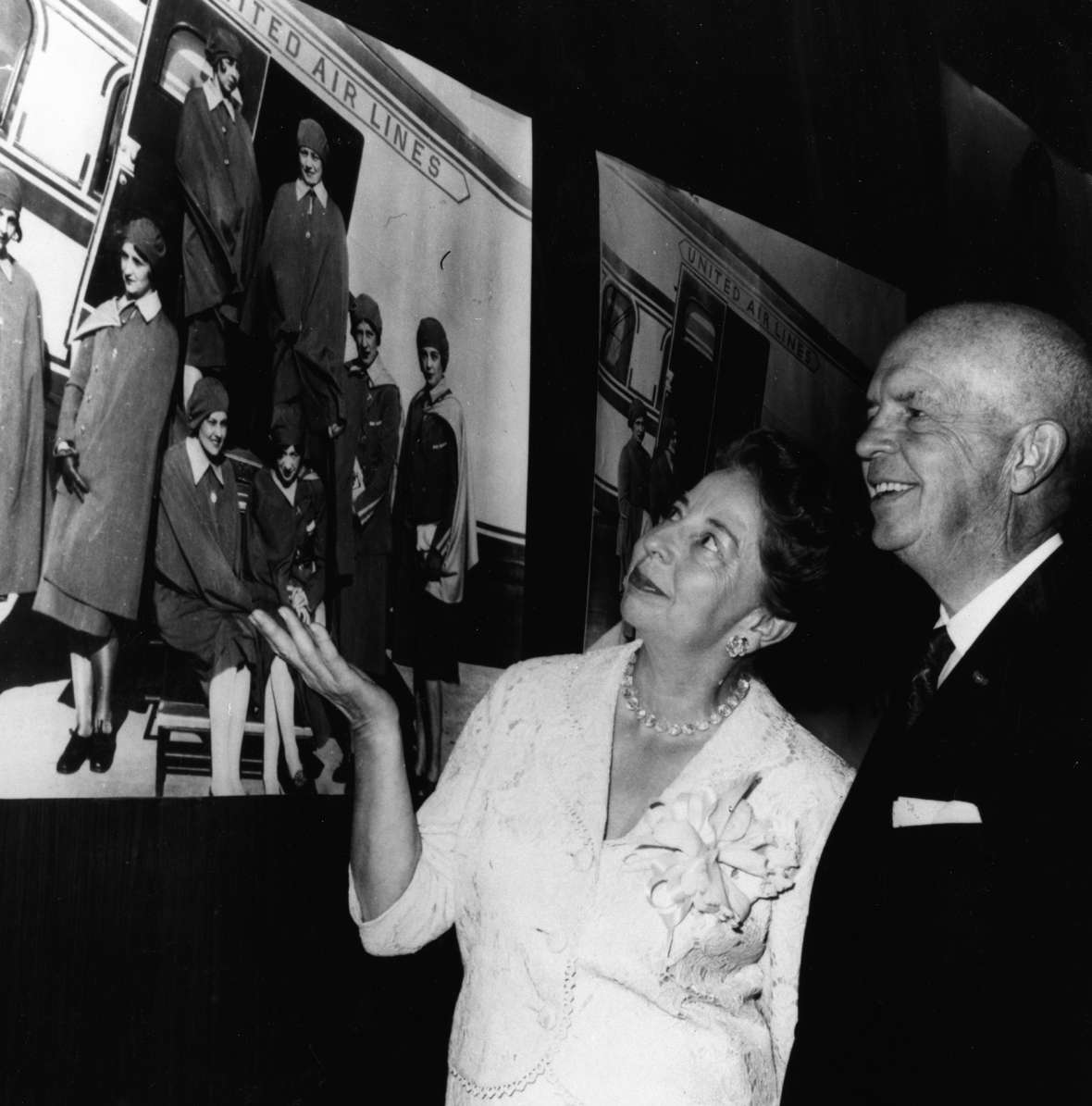 At the 30th anniversary of the United Air Lines stewardess service, Ellen Church and Steve Stimpson, the duo who first initiated the idea of hiring stewardesses, admire a photo of the original eight trained at Cheyenne in 1930. United Air Lines Archives.