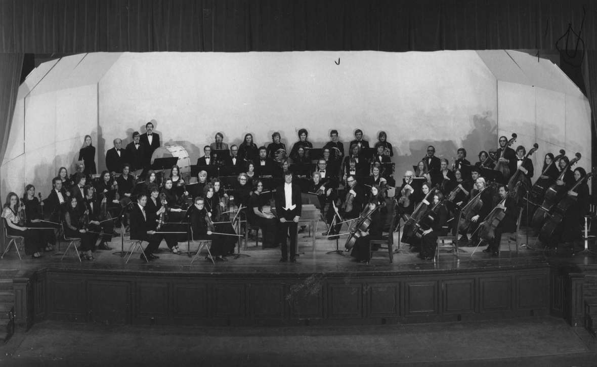 The Casper Symphony Orchestra, spring 1974, on the stage of the Natrona County High School auditorium in Casper shortly after Curtis Peacock, center, took over as music director. WSO archives.