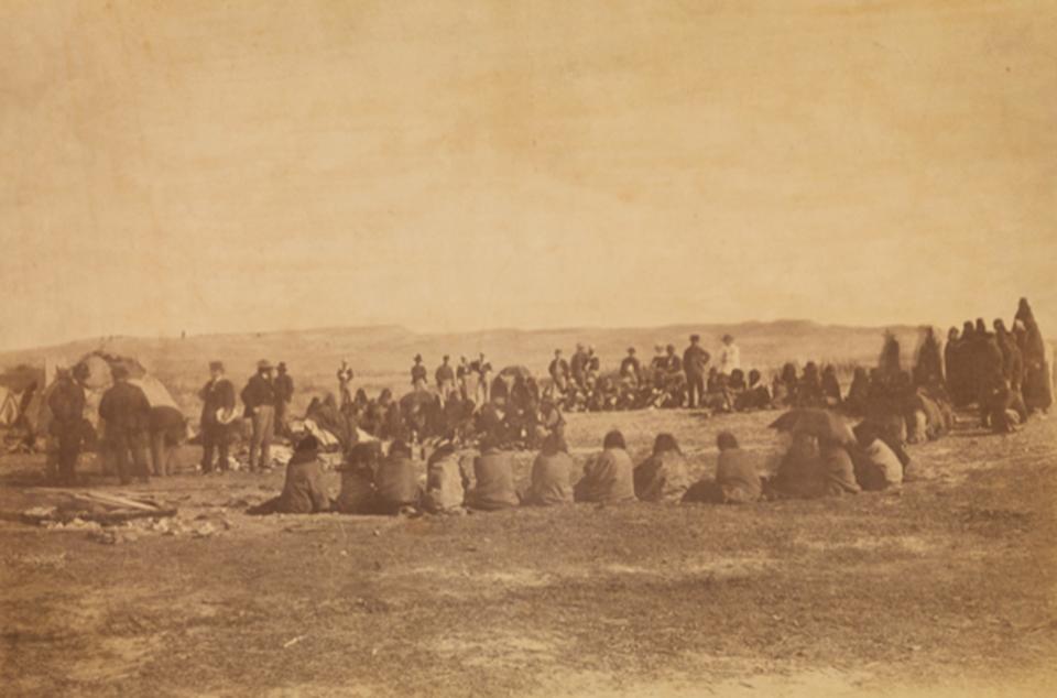 Apsáalooke (Crow/Absaroka) people receiving presents from the Indian peace commissioners at Fort Laramie, 1868. William T. Sherman collection of Gardner photographs; NMAI.