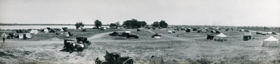 wide plain with no trees, scattered tent and vehicles