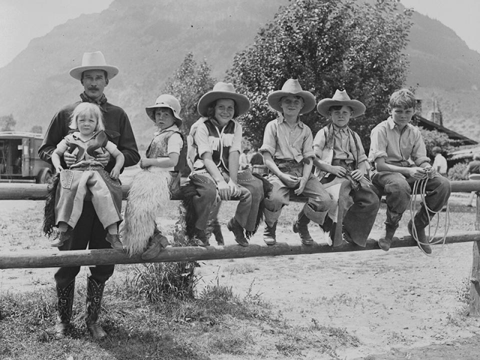 Valley Ranch owner Larry Larom and young dudes, 1930s. The ranch's brand is figured into the front of Larom's boots. Charles Belden photo, American Heritage Center.