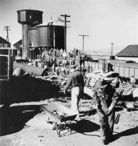 People load scrap metal into an open railroad car in Kemmerer, Wyo., 1942. Wyoming State Archives.
