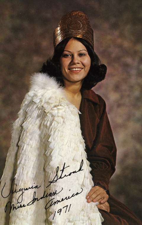 Miss Indian America XVII, Virginia Stroud of Tahlequah, Oklahoma, poses in contemporary clothes with a copper crown and a traditional Cherokee feather cape for her 1971 portrait. She declined to wear a Plains-style beaded buckskin dress, opting instead for trade cloth dresses and this cape, created from more than one thousand feathers sewn to a net backing. She believed contestants should be allowed to appear in contemporary clothing because regalia was not worn as daily dress. Miss Indian America Collection, THE Wyoming Room, SCFPL.