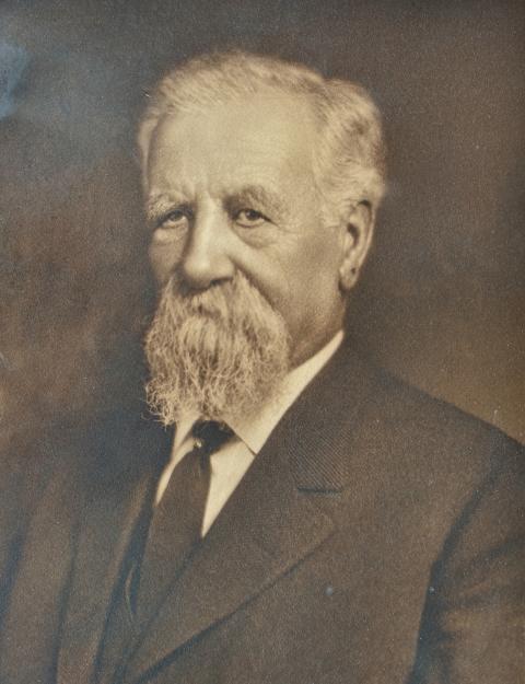 Eugene Amoretti Sr., known as the founder of Lander, Wyoming, authored the bill that would have moved the Agriculture School to Lander. Portrait of man with long white beard, wearing a tie