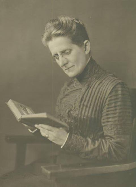 Grace Raymond Hebard Woman in a high-collared drass reads a book she holds in her hands