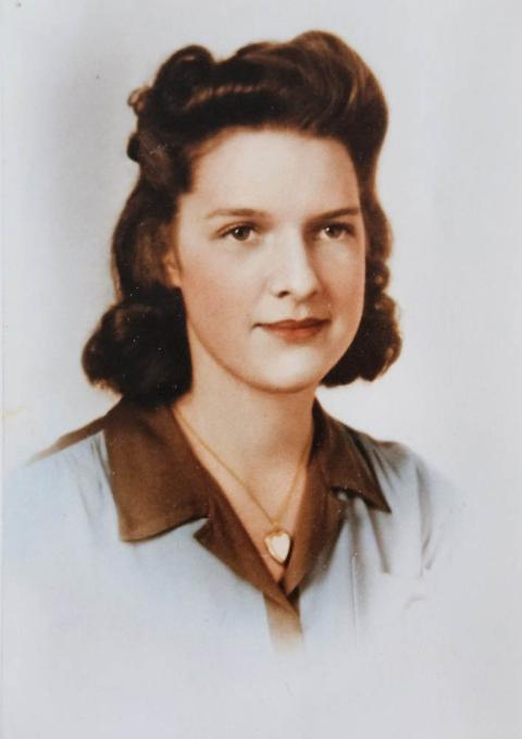 formal portrait of dark-haired young woman wearing a locket and collared shirt