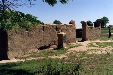 adobe walls with a historical marker in front
