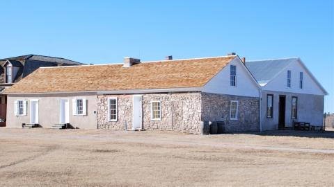 one-story stone building with two sections side-by-side, each with a peaked roof