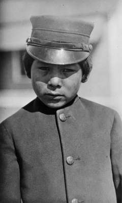 Arapaho schoolboy at the U.S. Government boarding school near Fort Washakie, 1913. Boys at the government school, where treatment was more severe than at the mission schools, wore military uniforms. J.K. Dixon photo, Wyoming Veterans Memorial Museum collections.