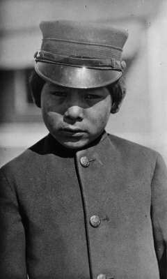 Unnamed schoolboy, at the government school near Fort Washakie, 1913. Boys at the U.S. Government boarding school, where treatment was more severe than at the mission schools, wore military uniforms. H.L. Dixon photo, Wyoming Veterans Memorial Museum collections.