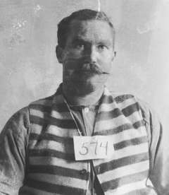 Bub Meeks, shown below in an Idaho State Penitentiary photo, was sentenced in 1896 to 35 years there. His sentence was later reduced; he would have been eligible for parole in 1904. But on Christmas Eve 1901 he cut a horse out of a wagon harness and escaped, was quickly caught, escaped again 20 months later and was shot in the leg. His leg was amputated. A few days later he attempted suicide by jumping off a cell house wall. Idaho State Archives. 